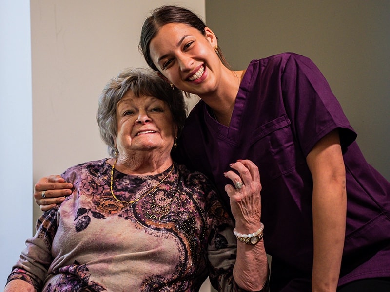 Care worker smiling with an older woman at home