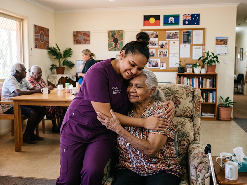 Care worker embracing an older woman in a residential care setting