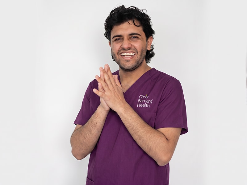 Chris Barnard Health nurse smiling in purple scrubs